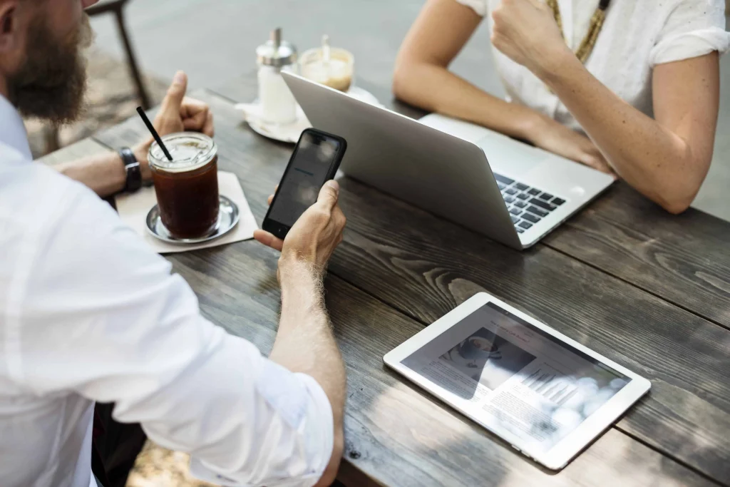 two people collaborating with online members at coffee shop